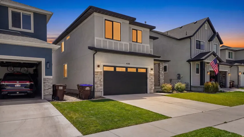 Modern two-story residence featuring a smooth stucco exterior with stone accents
