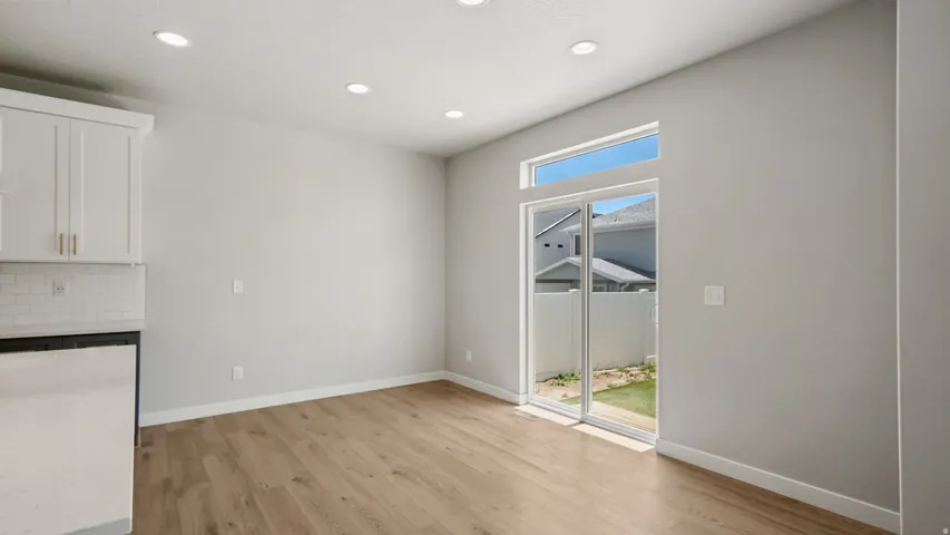 Open-concept room featuring wood-finish flooring, recessed lighting, and a white subway tile backsplash