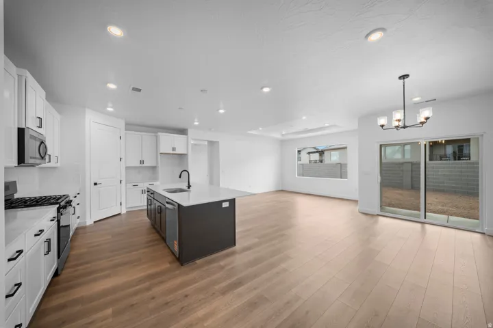 Open-concept living area featuring wood-finish flooring, recessed lighting, and a modern kitchen