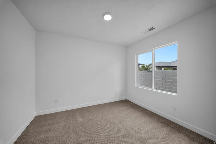 Bright interior space featuring a window, recessed lighting, and neutral carpeting
