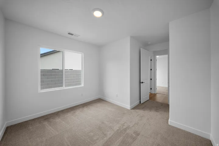 Carpeted room with a recessed ceiling light, white walls, and white baseboards