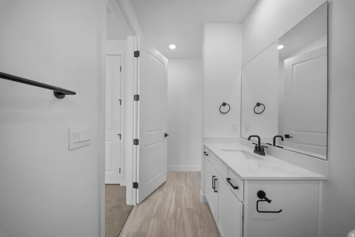 Modern bathroom featuring a single vanity with a white countertop, undermount sink, and matte black faucet