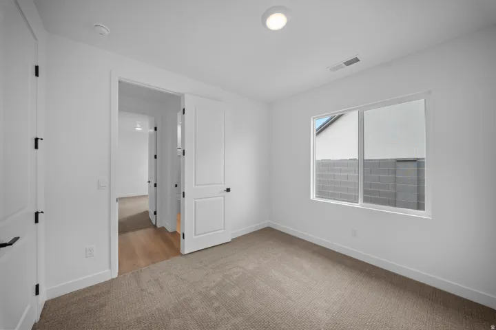 Neutral toned carpeting complemented by crisp white walls and baseboards