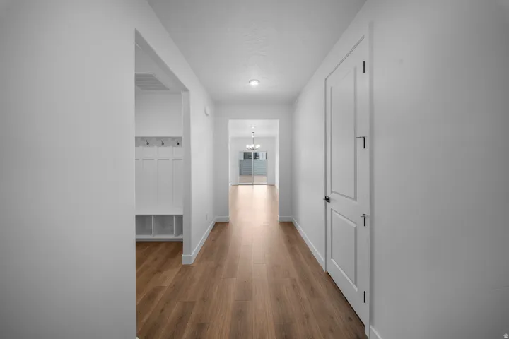 Entryway featuring wood-finish flooring, recessed lighting, and a built-in mudroom bench with coat hooks and storage cubbies