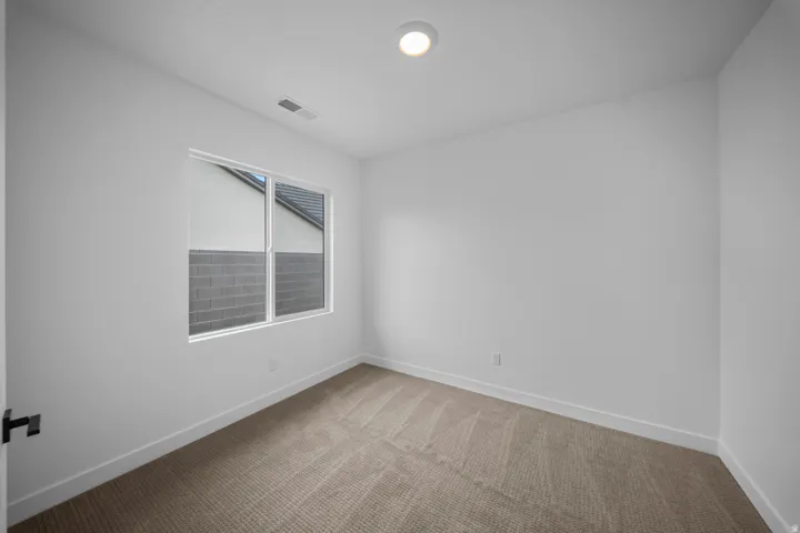 Bright room featuring a window with white trim, recessed lighting, neutral carpet, and white baseboards