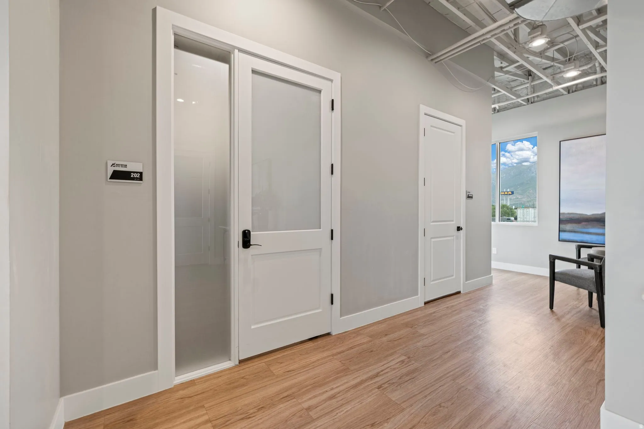 Hallway featuring wood-finish flooring and light gray walls