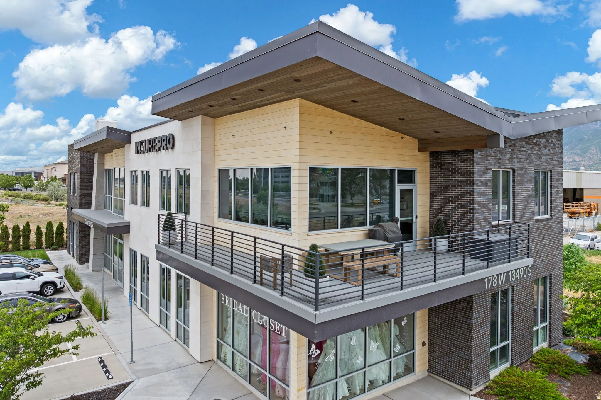 Modern commercial building featuring a multi-textured facade with stone, brick, and horizontal paneling
