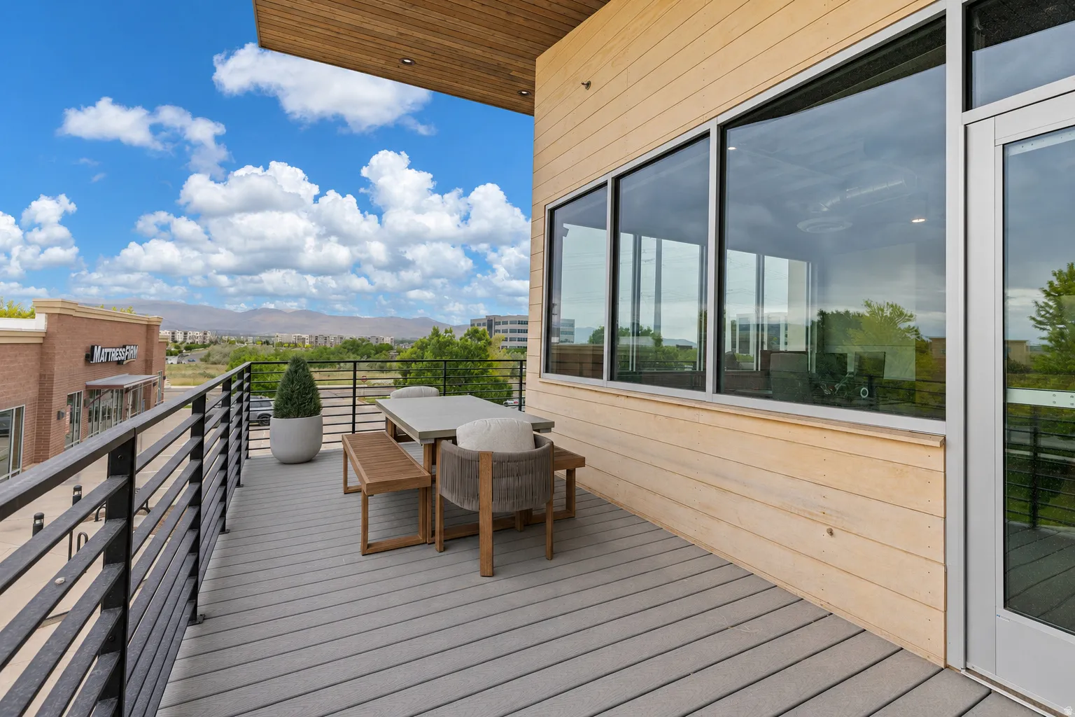 Expansive balcony featuring composite decking and a black metal railing