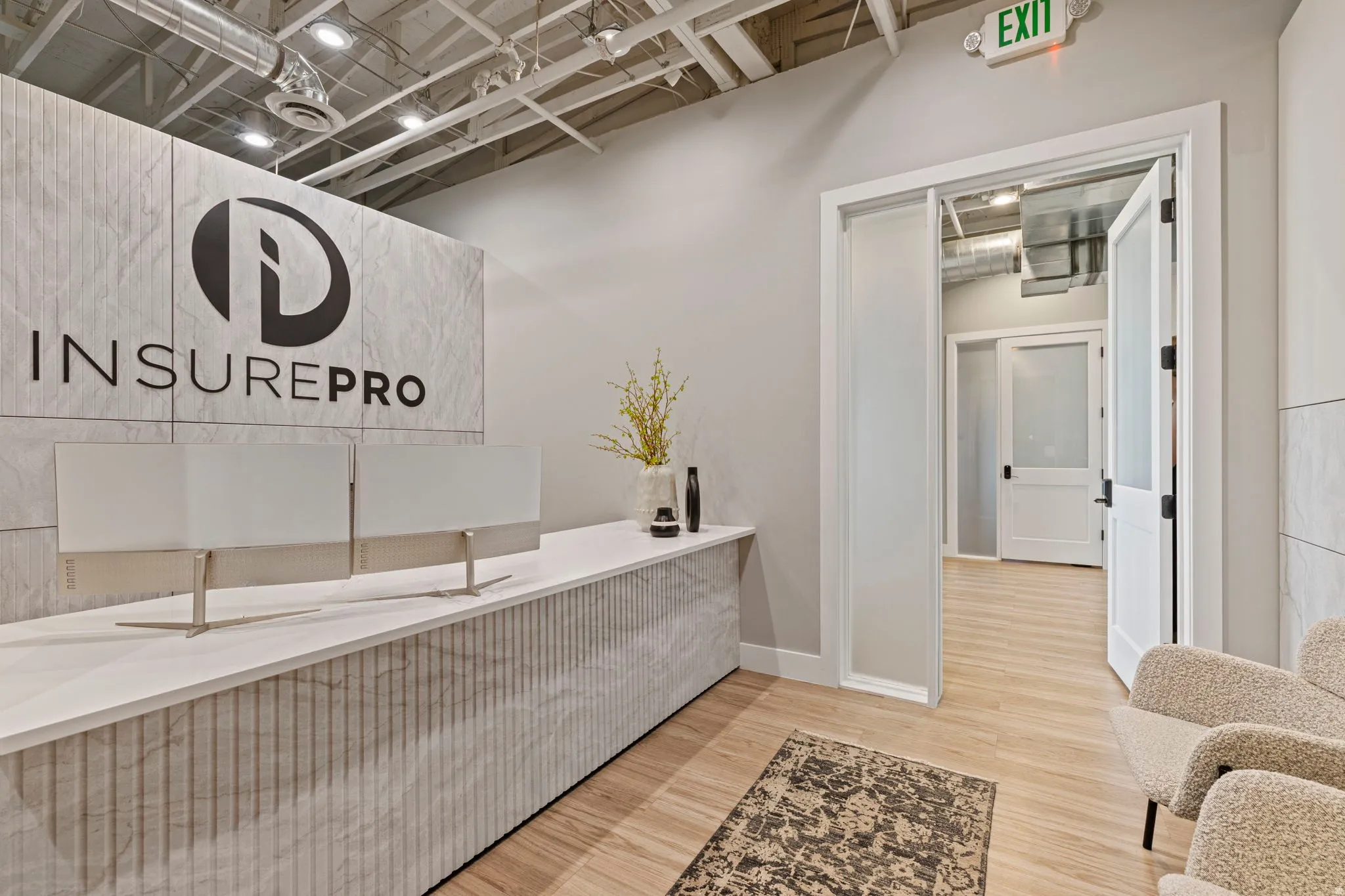 Modern reception area featuring a fluted white stone-look reception desk with a stone-look backsplash
