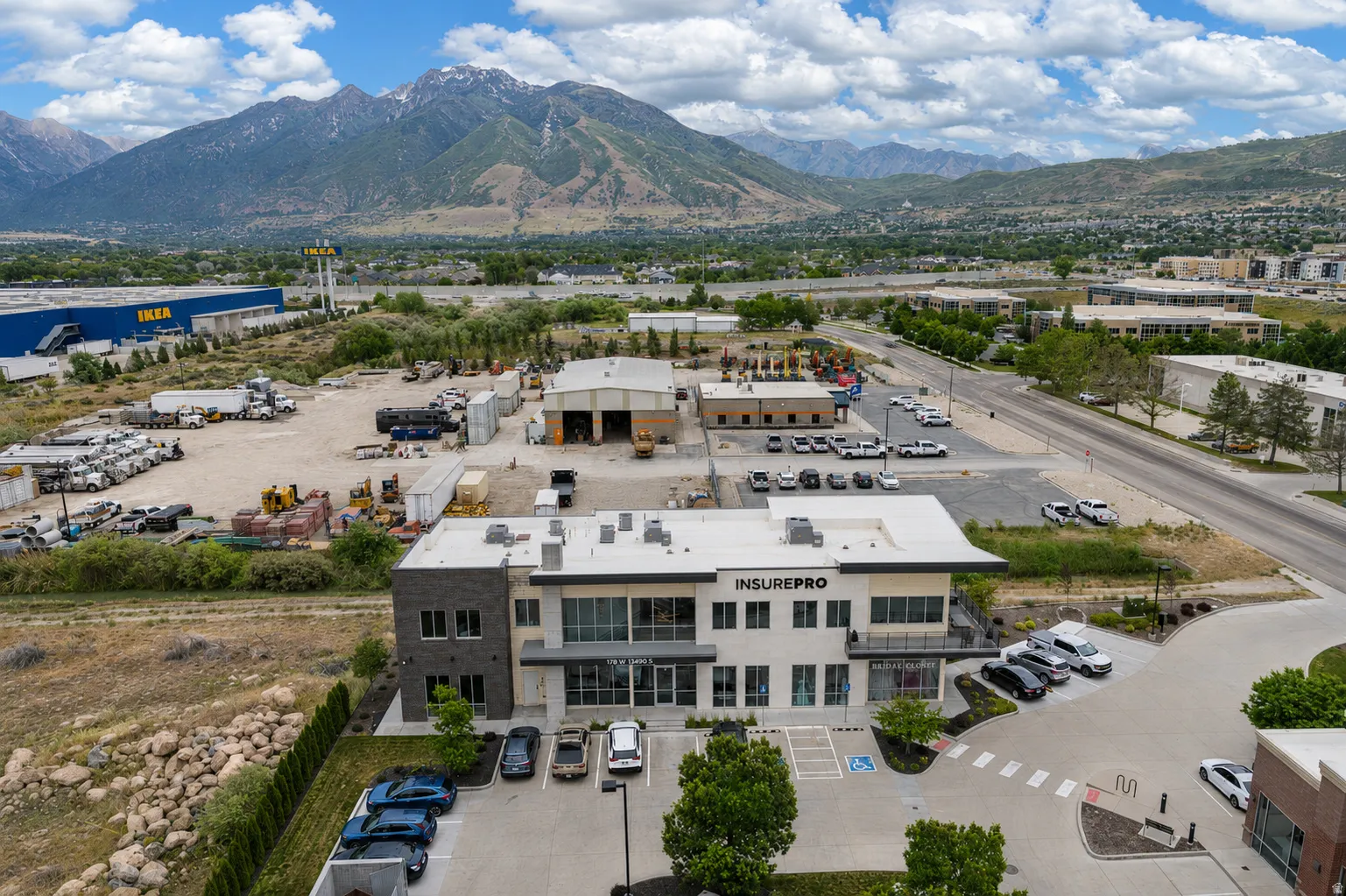Modern commercial building with a stone and stucco facade, featuring large windows and a distinct entrance canopy