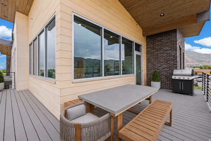 Expansive outdoor deck featuring composite decking, wood-finish siding, and a partial wood-paneled ceiling
