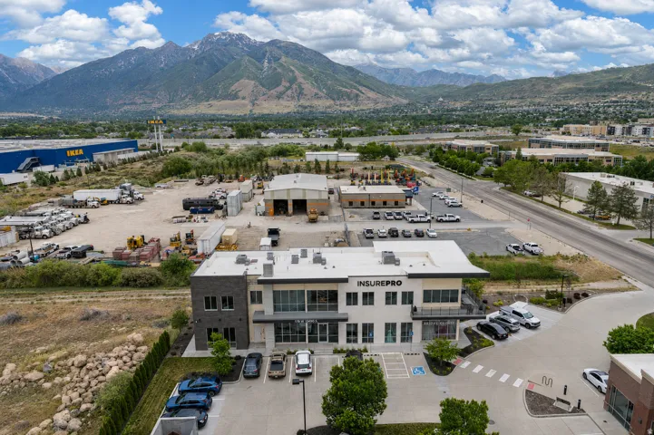 Modern commercial building with a stone and stucco facade, featuring large windows and a distinct entrance canopy