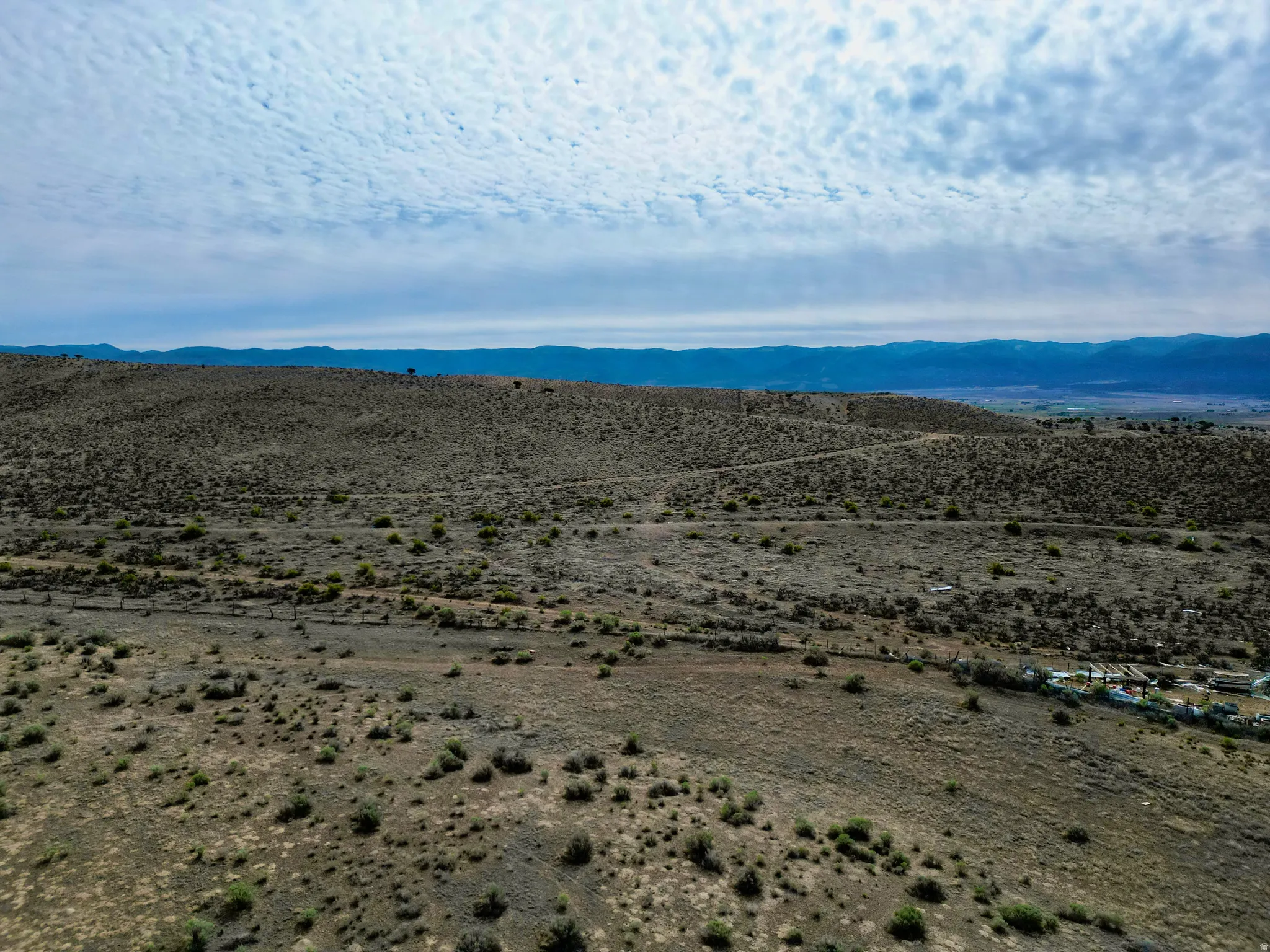 Expansive undeveloped land featuring rolling hills and distant mountain ranges