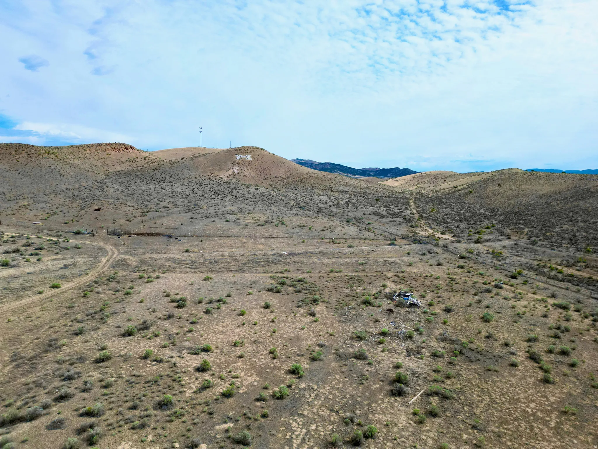 Expansive desert landscape featuring rolling hills and sparse vegetation