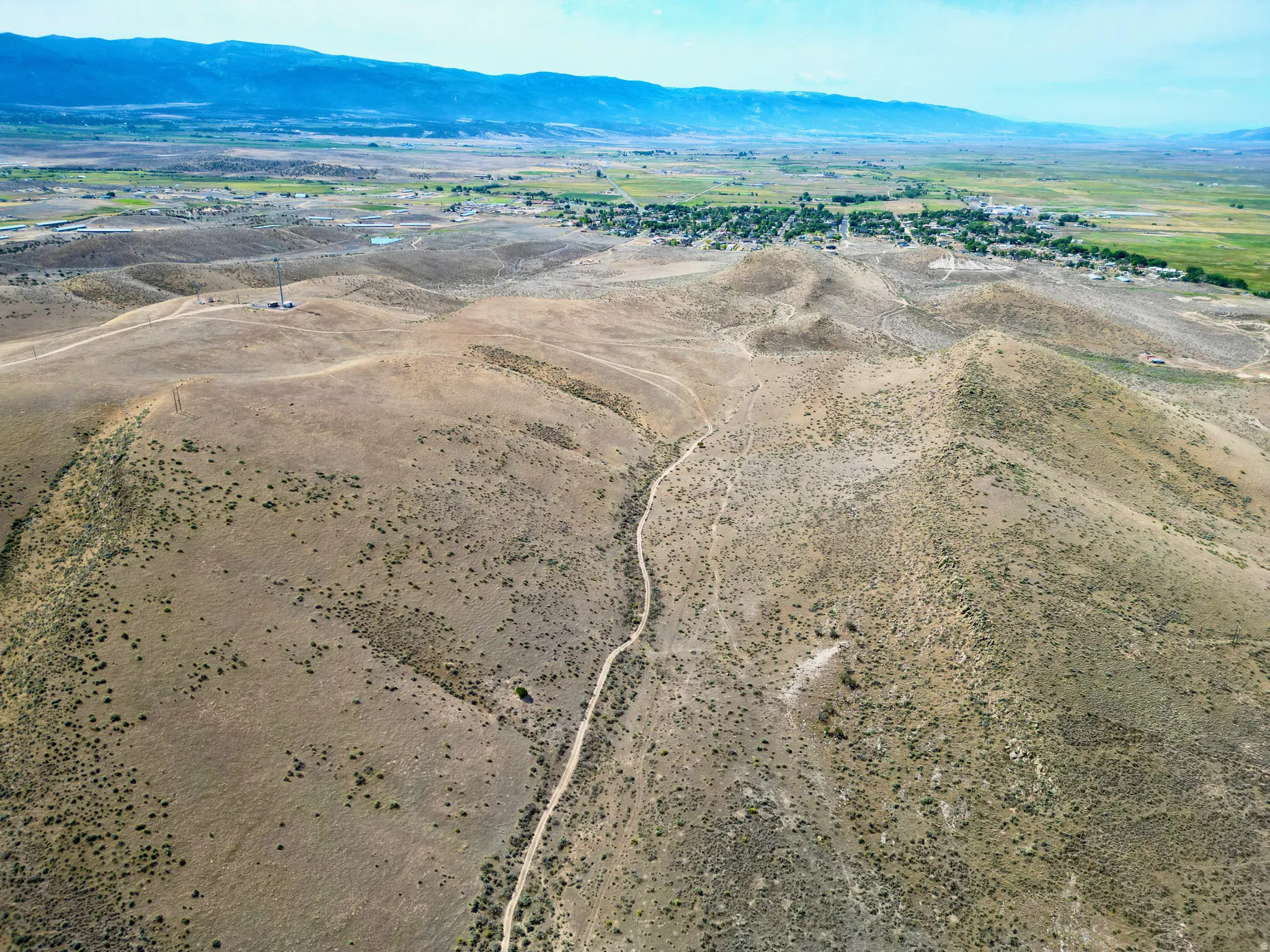 Expansive undeveloped terrain featuring a winding dirt path and sparse vegetation