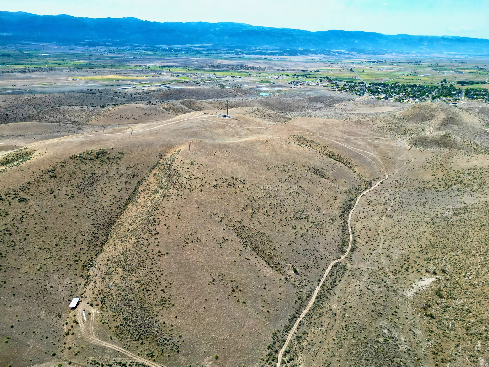 Expansive arid landscape featuring rolling hills and distant mountains