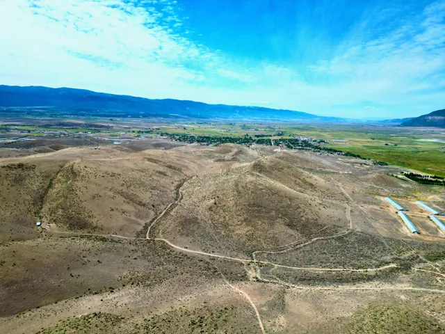 Expansive rural landscape featuring rolling hills and distant green fields