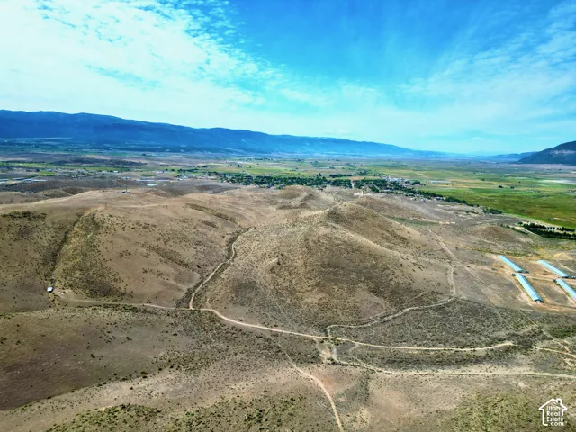 Expansive rural landscape featuring rolling hills and distant green fields