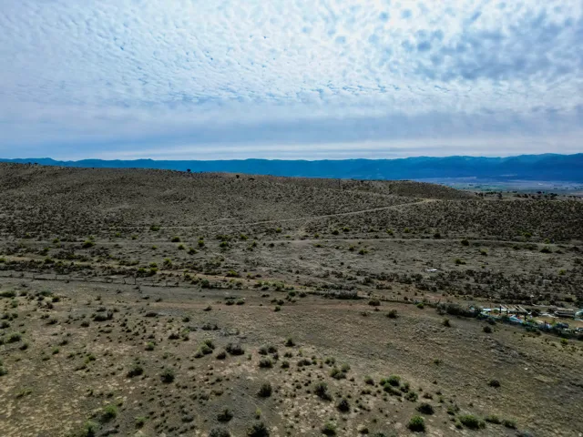 Expansive undeveloped land featuring rolling hills and distant mountain ranges
