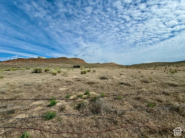 Expansive open land with natural desert flora and distant geological formations