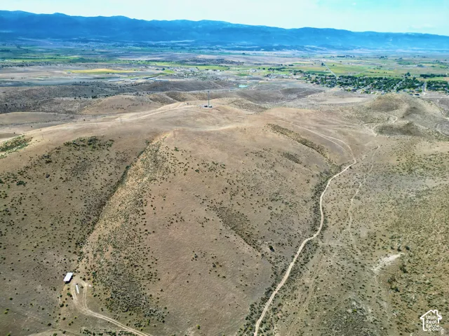 Expansive arid landscape featuring rolling hills and distant mountains