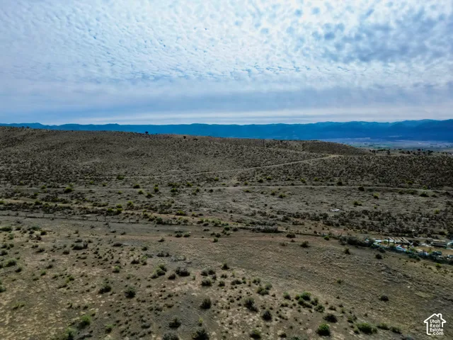 Expansive undeveloped land featuring rolling hills and distant mountain ranges