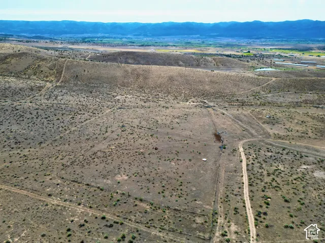 Expansive, undeveloped parcel featuring varied topography and distant mountainous terrain