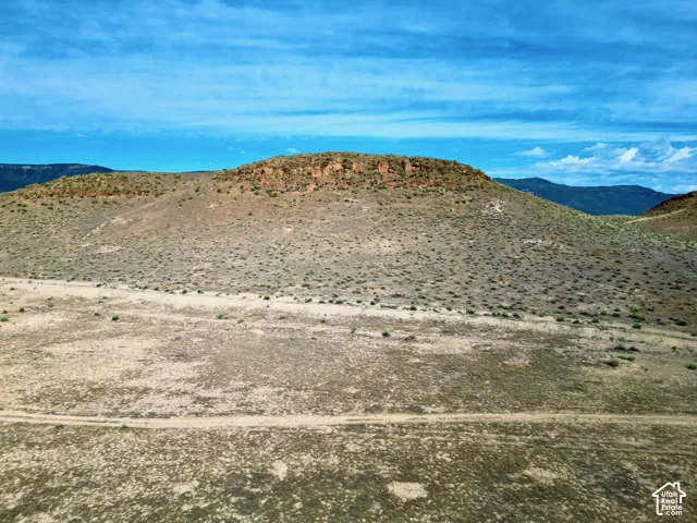 Expansive desert landscape featuring a prominent mesa with visible rock formations