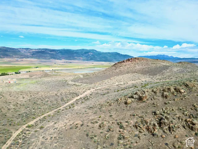 Expansive land parcel featuring a rugged, elevated terrain and a visible dirt path