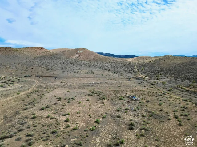Expansive desert landscape featuring rolling hills and sparse vegetation