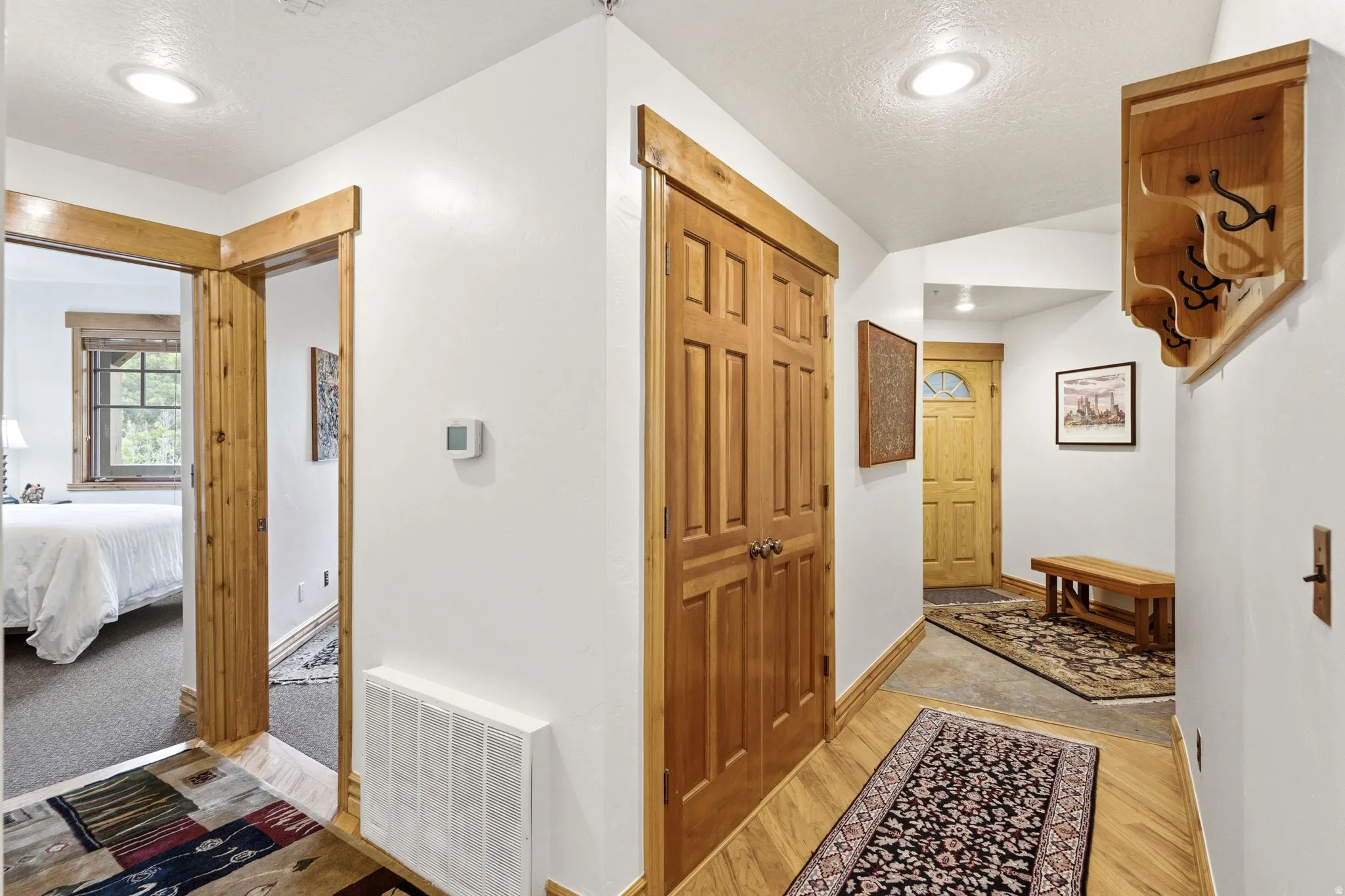 Hallway featuring wood-finish flooring, white walls, and recessed lighting