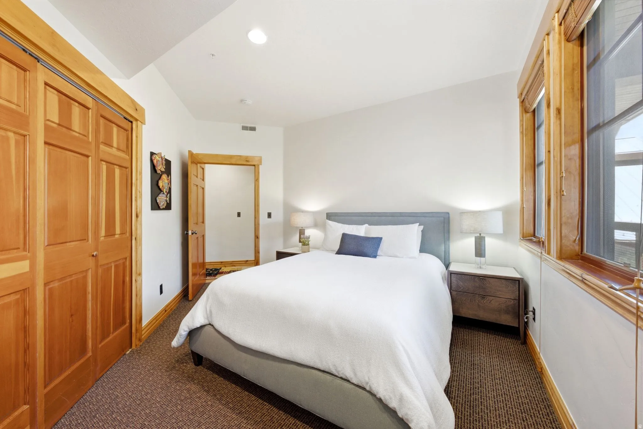 Vaulted ceiling bedroom with natural wood trim and doors