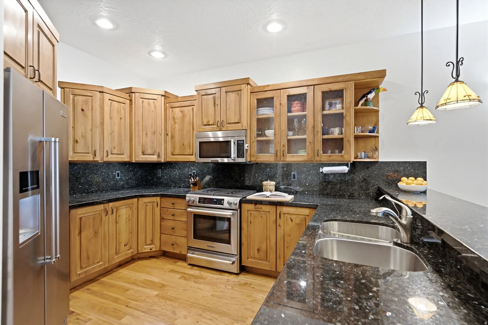 Kitchen featuring wood-finish cabinetry, dark speckled countertops, and stainless steel appliances
