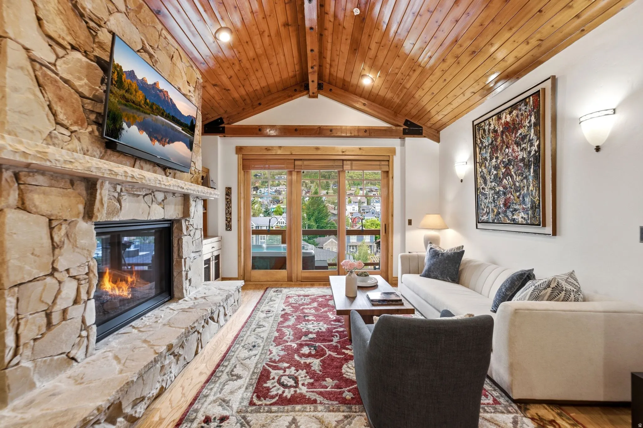 Living area with a stone fireplace and wood-finish flooring