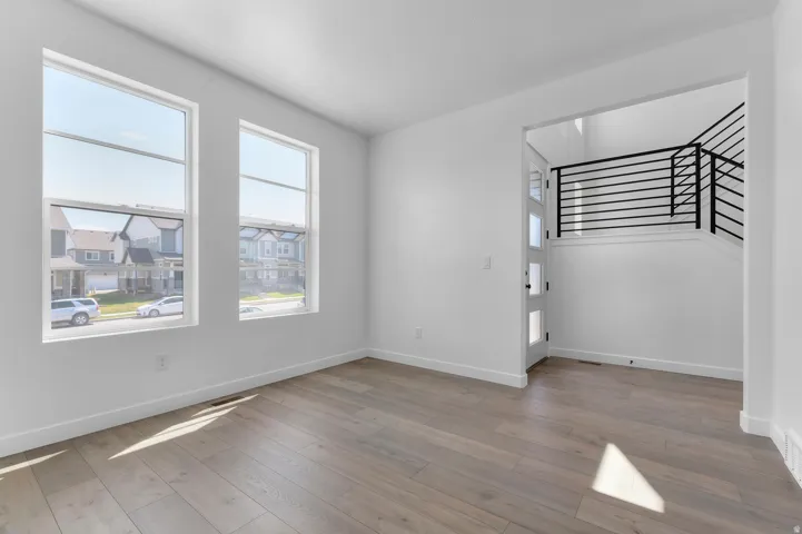 Interior space featuring light wood-finish flooring, white walls, and bright natural illumination from two large windows