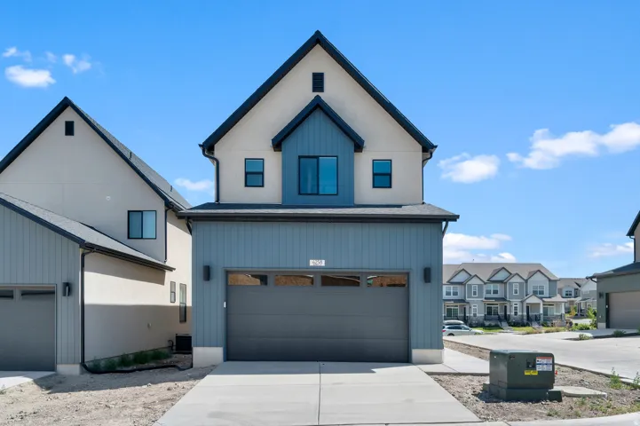 Modern architectural design featuring a prominent front-facing garage with a dark gray door