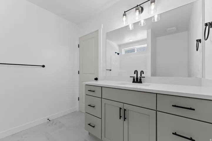 Bathroom featuring a light gray vanity with a white countertop and a single undermount sink