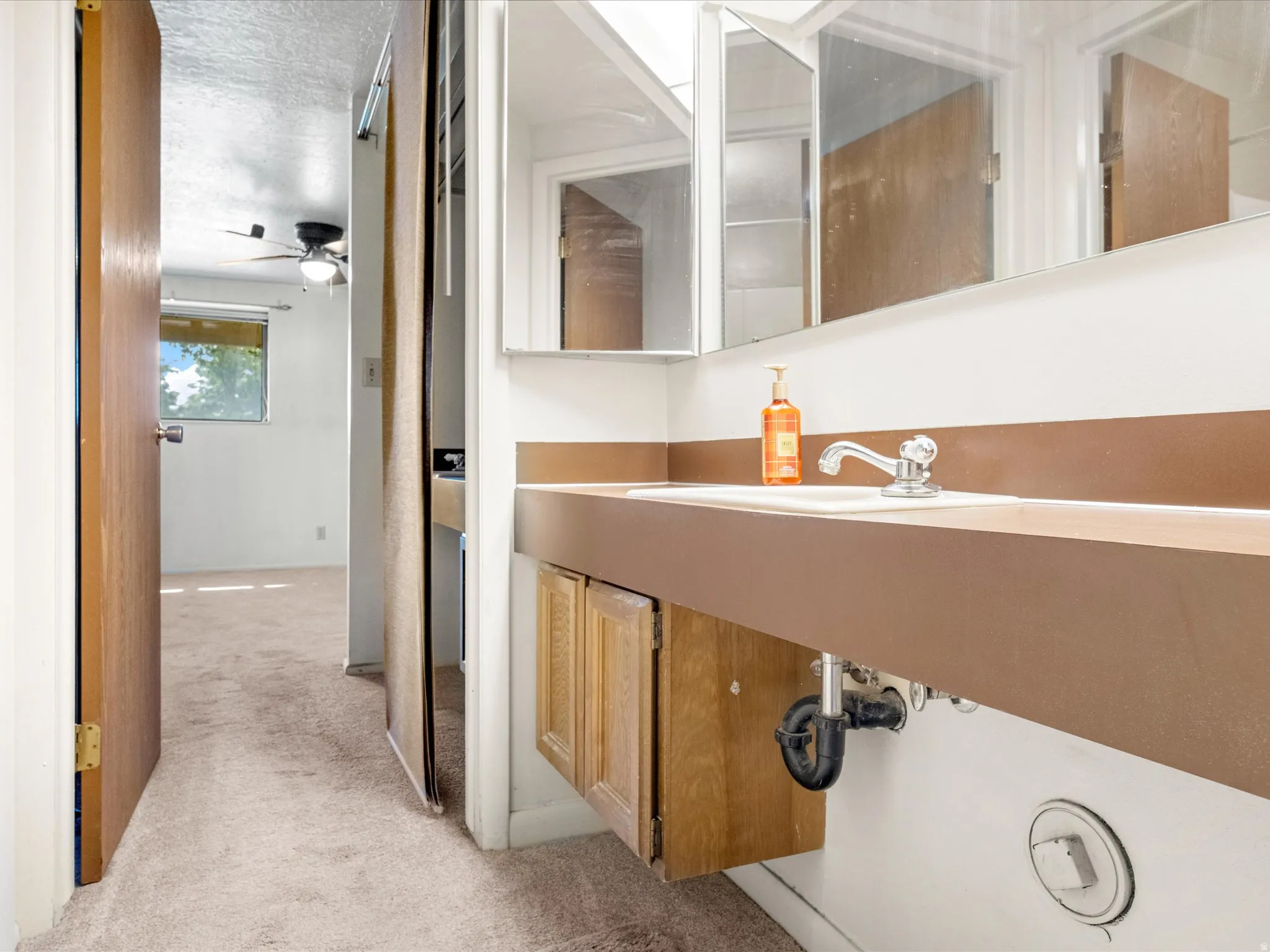 Vanity featuring an integrated sink, dual mirrored medicine cabinets, and wood-finish cabinetry