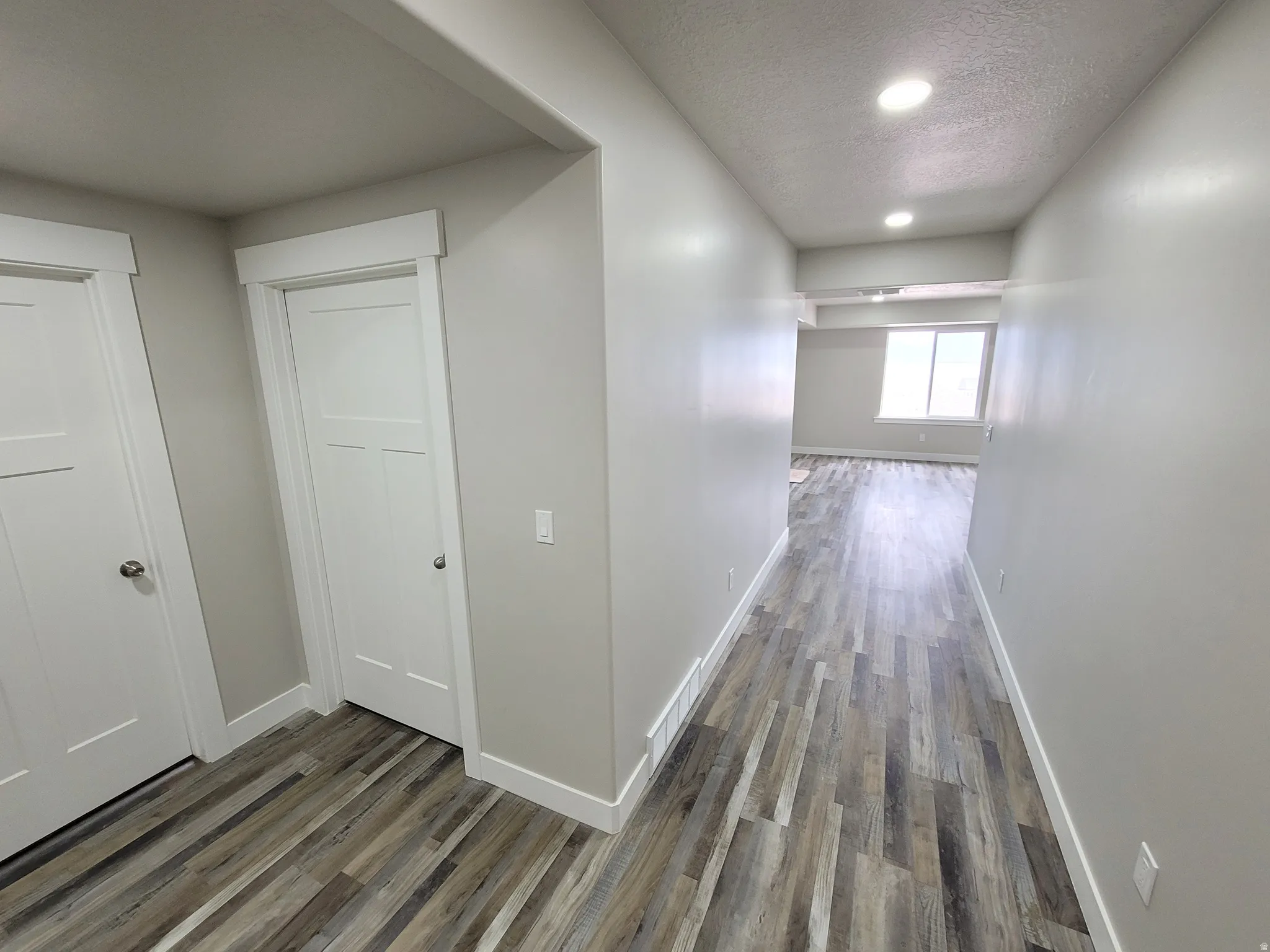 Hallway with wood-finish flooring, recessed lighting, and modern white trim