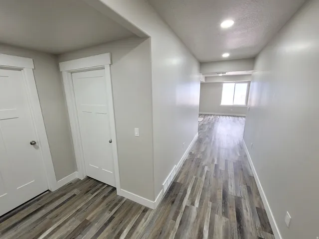 Hallway with wood-finish flooring, recessed lighting, and modern white trim