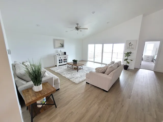 Open-concept living space with vaulted ceilings, recessed lighting, and wood-finish flooring