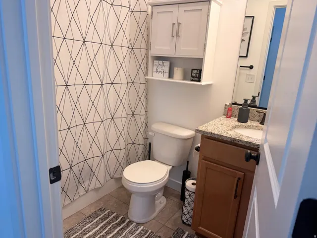 Bathroom featuring a light-toned vanity with a granite-style countertop and an undermount sink