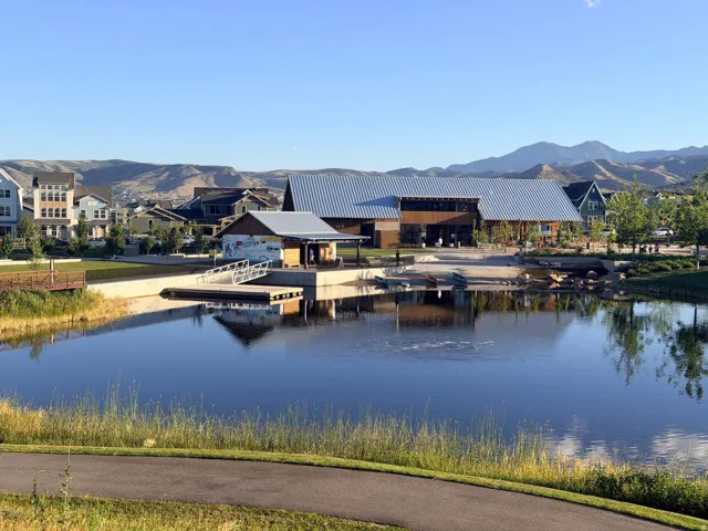 Expansive water feature with a boat launch and dock, bordered by a paved walking path