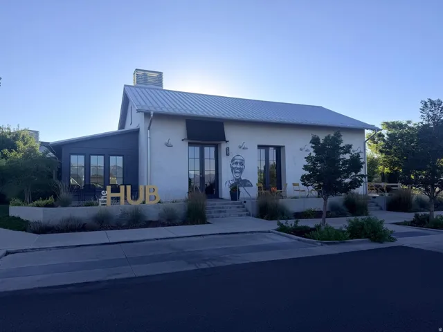 White stucco exterior with a dark metal roof and a prominent "The HUB" sign