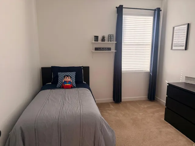 Bright room featuring neutral carpeting and white wall finishes