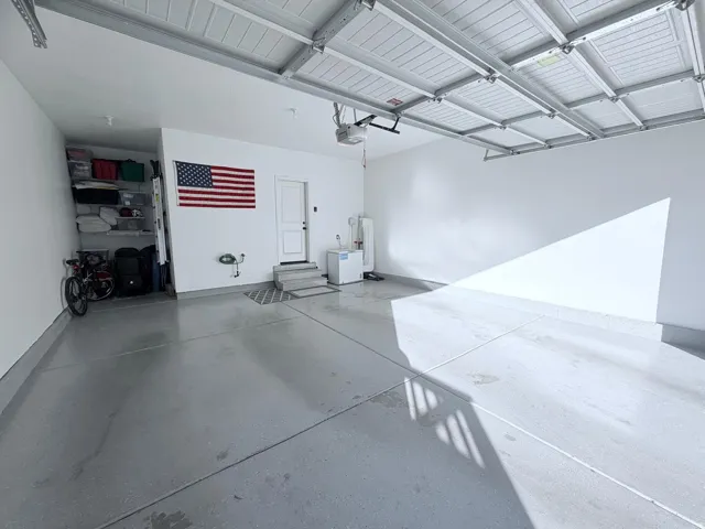Spacious garage featuring a light gray concrete floor and white painted walls