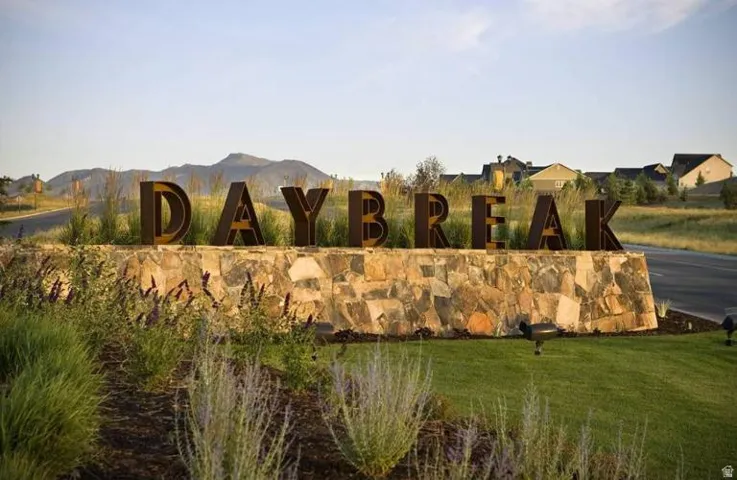 Entryway sign featuring large, dark-toned dimensional letters atop a natural stone base