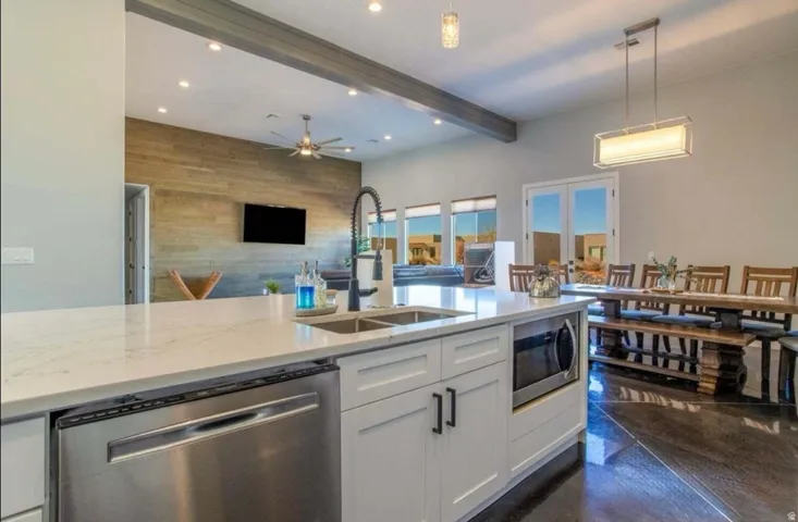 Kitchen island with a built-in stainless steel dishwasher, undermount sink, and microwave