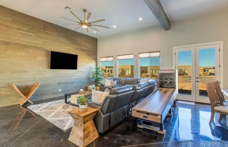 High ceilings, wood panel accent wall, recessed lighting, polished concrete flooring, and multiple windows