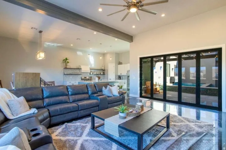 Expansive living area with high ceilings, recessed lighting, and a ceiling fan
